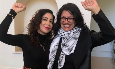 Two women embrace and raise fists