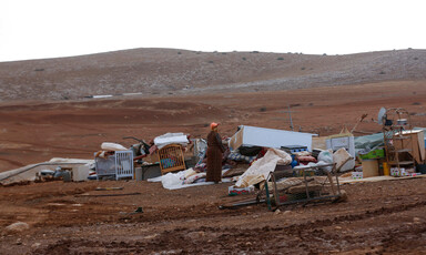 Woman inspects destroyed structures