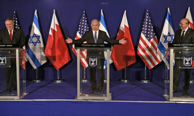 Three men in suits give speeches on podiums