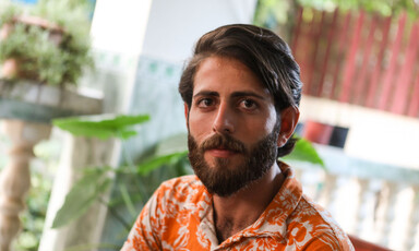 Man sits in front of plant 