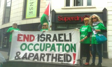 Four women hold a banner reading "End Israeli occupation and apartheid!"