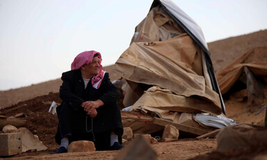 Man looks at the pile of rubble around him