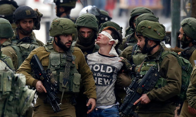 Soldiers arrest a blindfolded boy