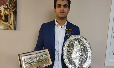 Man holds plaque in each hand 