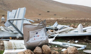 A demolished shelter beside a hill 