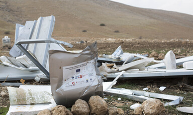A demolished shelter beside a hill