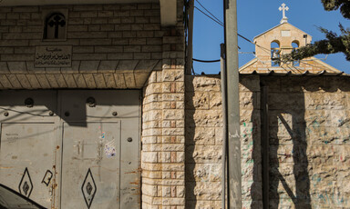 Church bells can be seen behind a shuttered metal door