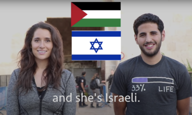 Two people stand side by side with Palestinian and Israeli flags