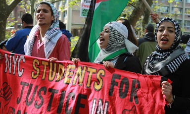 Demonstrators hold a banner that says Students for Justice in Palestine