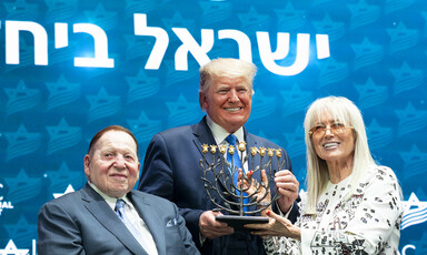 A man holding menorah candlestick flanked by a couple