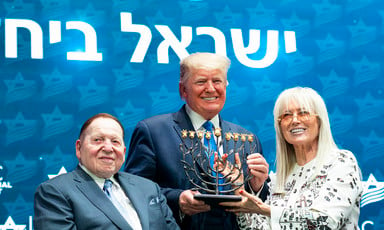 A man holding menorah candlestick flanked by a couple