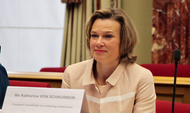 Smiling woman sits at table