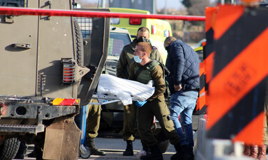 Soldier loads stretcher into military vehicle