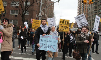 Demonstrators hold signs protesting Fordham's ban of SJP