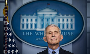 Man seen from chest up by White House seal