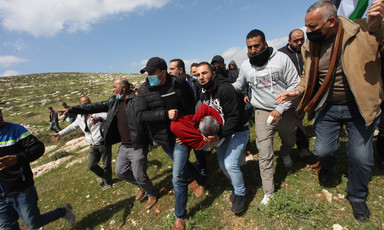 Men carry the body of an injured protestor 