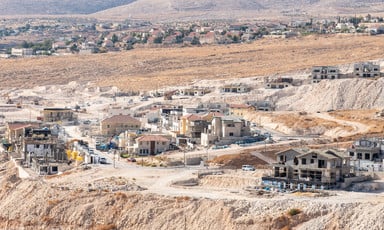 Broad view of unfinished buildings against arid landscape