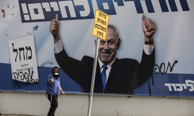 An election poster covered with graffiti carries Benjamin Netanyahu's triumphant image