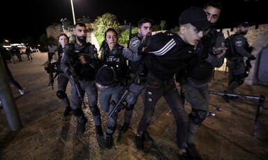 Men and women in uniform restrain a young man