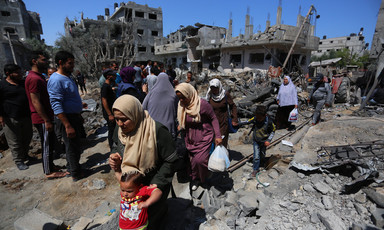 Women walk amid rubble 