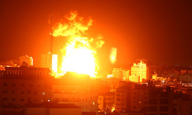 Landscape view of a massive fireball over a city skyline at night