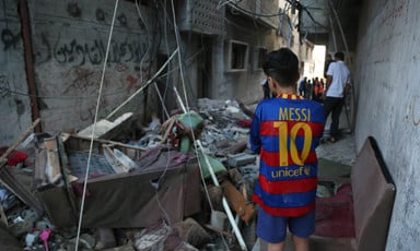 Child stands amid debris left after a bomb attack 