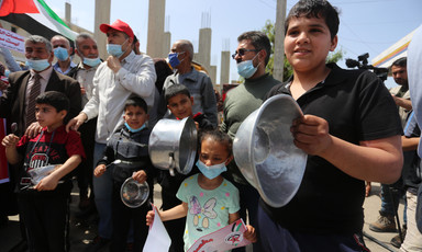 A group of people, some holding kitchen utensils 