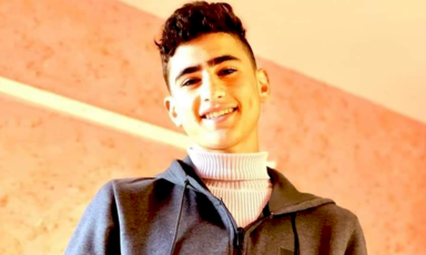 Boy smiling wearing turtle neck and a hoodie 