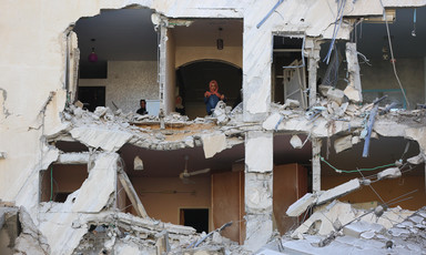 Women stand inside building with torn off facade