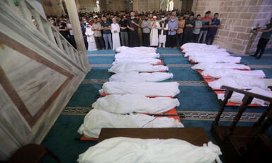 People pray at the mosque over 17 bodies wrapped in shrouds