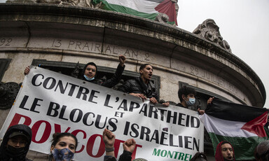 Protesters raise their fists in the air while holding banner