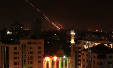 A streak of light from a rocket blazes through a dark sky