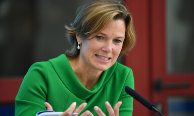 Woman sits behind microphone 