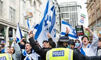 Young people waving Israeli flags and chanting