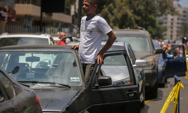 Man steps out the door of his car amid queue 