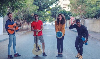 A group of people hold musical instruments 