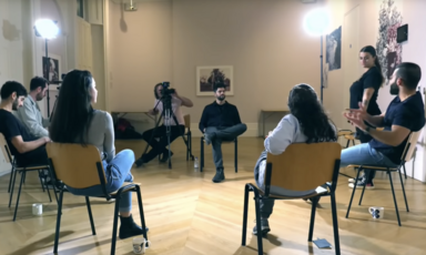 A group of people sitting in a circle are filmed