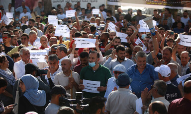 Demonstrators hold up signs in Arabic