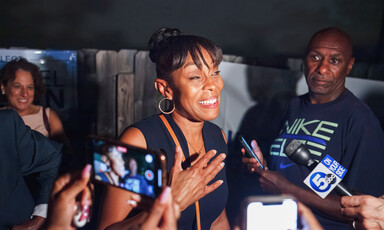 Woman expresses joy before two onlookers