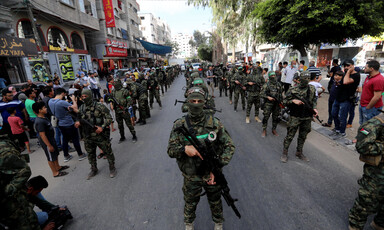 A parade of masked men, carrying guns 
