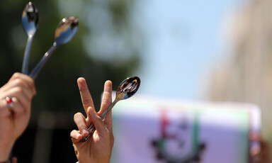 Hands hold up spoons and victory signs