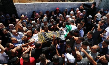 Crowd carries a body wrapped in an Islamic Jihad flag