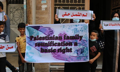 Two children hold a poster reading "Palestinian family reunification is a basic right"