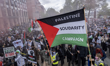 A flag banner in a crowd of people reads "Palestine Solidarity Campaign"