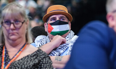 Man in hat wears Palestinian headscarf and facemask in colors of Palestinian flag