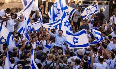 Man in crowd waving Israeli flags