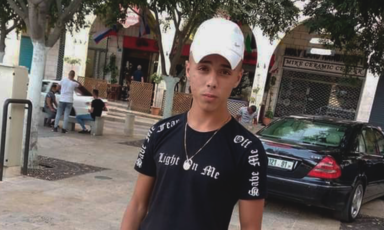 Boy stands in the street wearing cap 