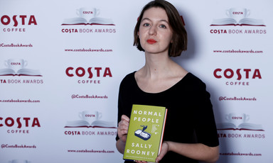 Woman holds a copy of a book 