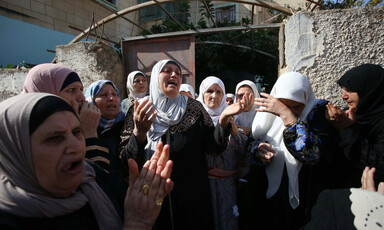 Women weeping and crying at the entrance to a house