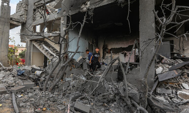 Children stand in the rubble of a bombed building 